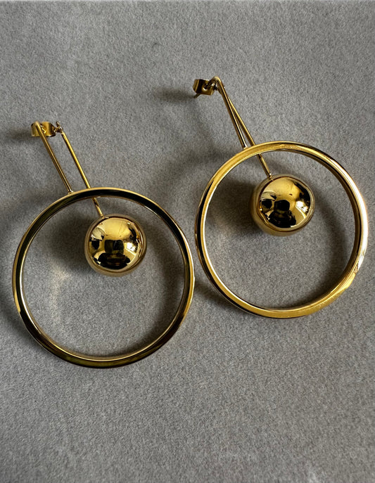 A pair of gold earrings adorned with circular motifs, exemplifying sophistication and timeless elegance in jewelry design.