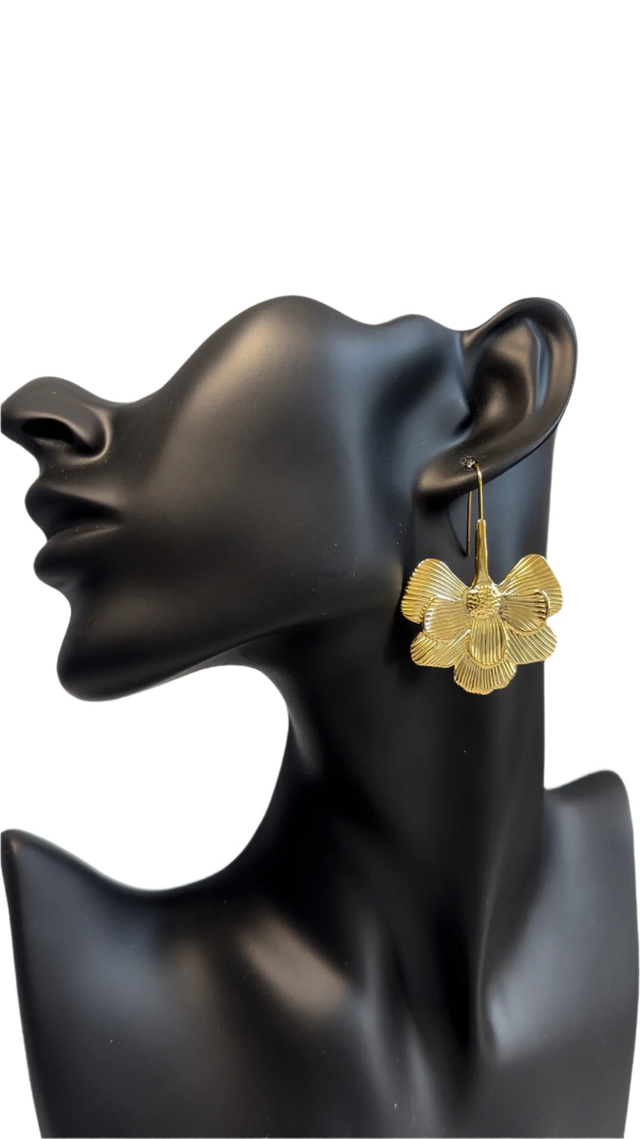 A delicate gold earring featuring a beautifully crafted flower design, showcasing elegance and charm on a black mannequin.