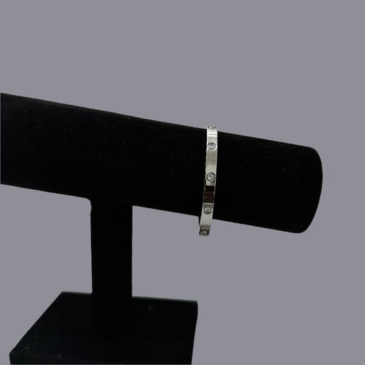 Elegant silver detailed bangle displayed on a black velvet jewelry stand against a white background, perfect for showcasing minimalist jewelry designs.